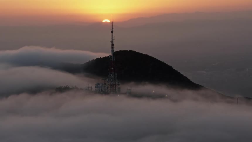 Stunning 4K aerial footage capturing the sun setting behind the Hollywood Hills and iconic radio tower amidst the marine layer in Southern California