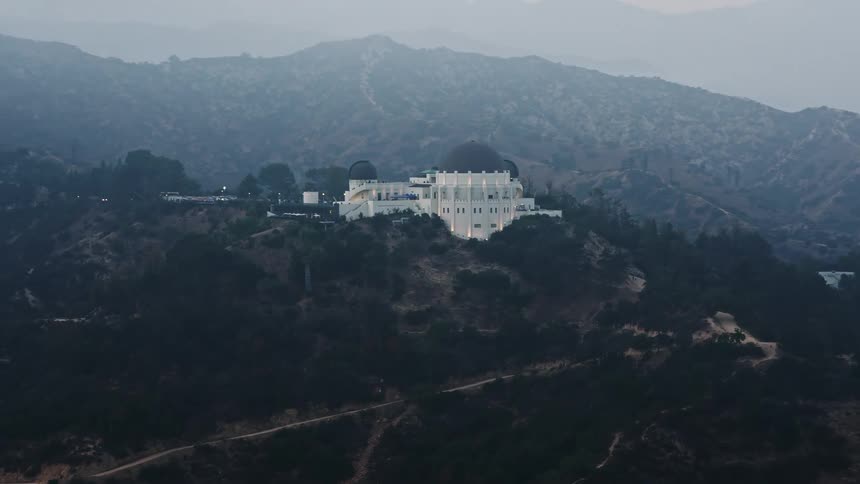 A stunning 4K aerial footage of Griffith Observatory in Los Angeles California orbiting in fog during sunset