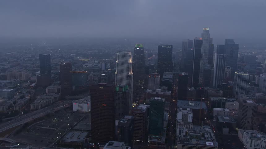Aerial footage of downtown Los Angeles skyscrapers through a mesmerizing marine layer during twilight