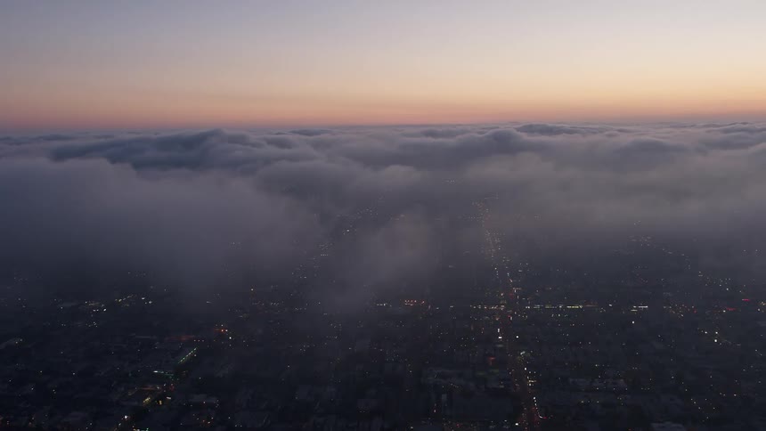 A stunning 4K aerial footage capturing the twilight scenery of Los Angeles from above the marine layer