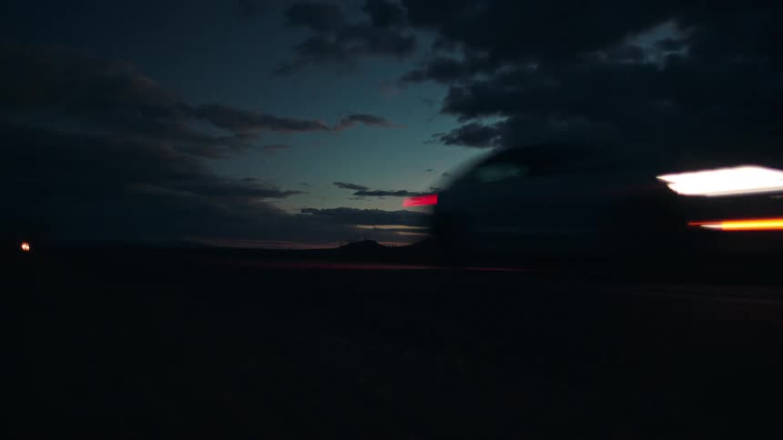 A car speeds down a road at night