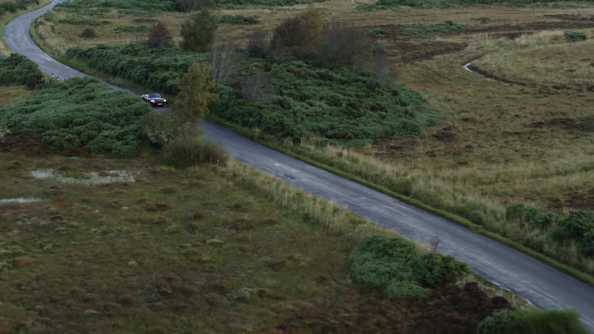The car drives down the long road