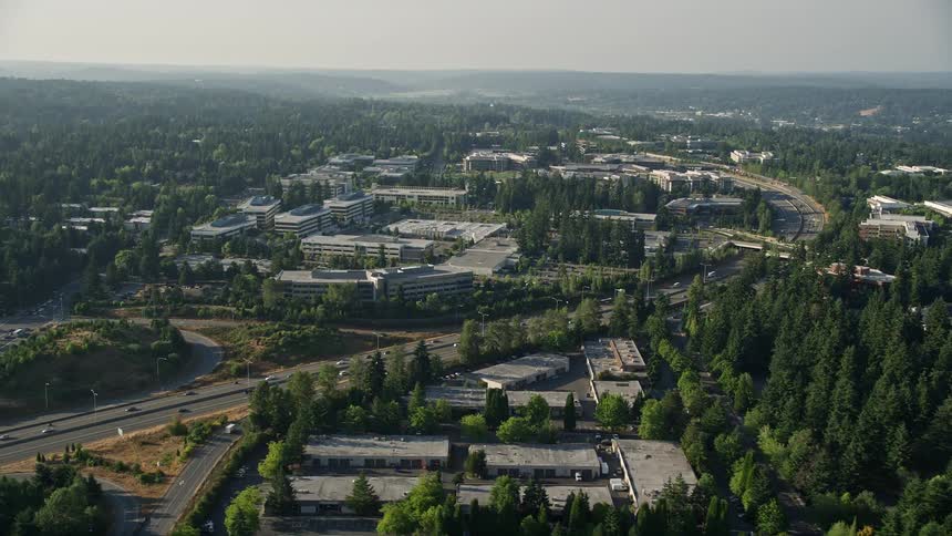 Aerial footage of Microsoft Headquarters in Redmond Washington showcasing the building complex in a forest surrounded by highways