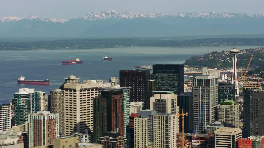 Multiple building constructions progress in downtown near freighter occupied water