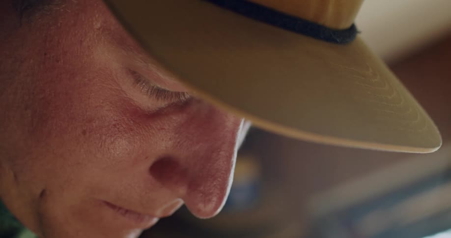 Close up of mans face looking down at golf clubs