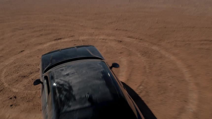 A black car is doing doughnuts