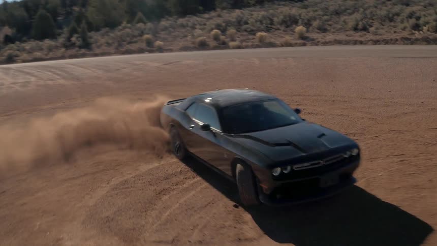 A black car is doing doughnuts in a field