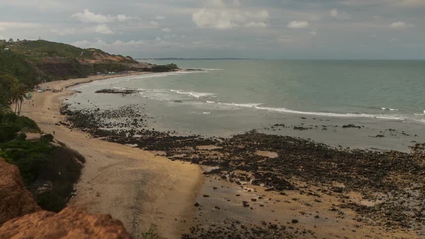 People walk around beach in northeast Brazil beach Pipa as waves roll in