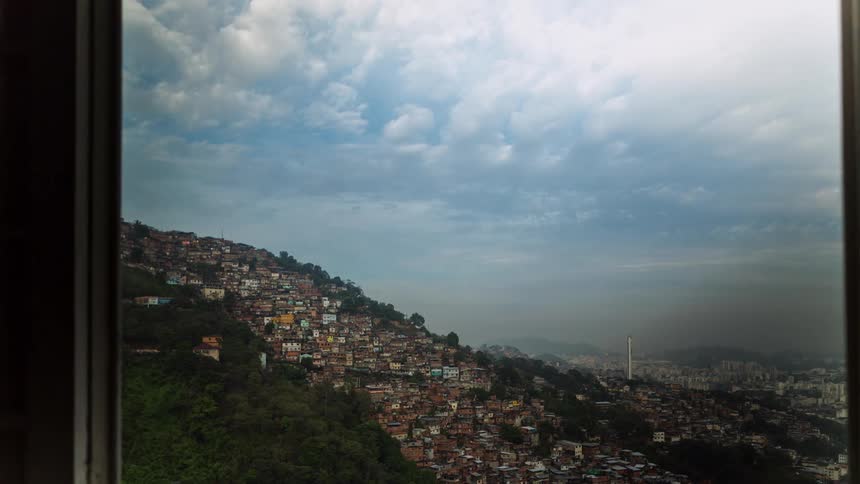 A time lapse of clouds moving over the city of Rio as seen from an opened window in a hill