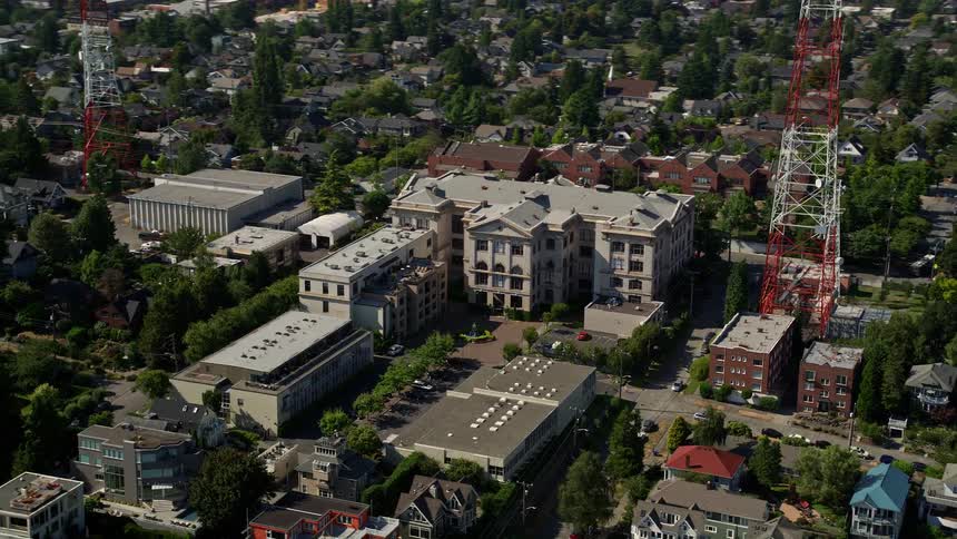 Aerial footage of Queen Anne High School in Seattle Washington showcasing the school and surrounding residential area with lush green trees