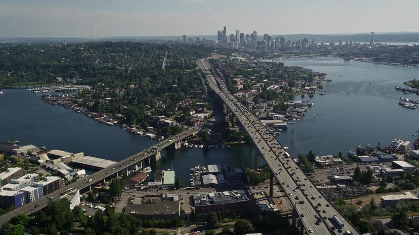 Aerial footage revealing Ship Canal Bridge and Seattle's downtown skyline as the camera tilts up to showcase Lake Union and the city's metropolis