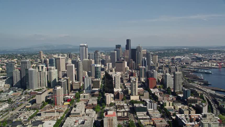 Aerial footage captures the vibrant metropolitan skyline of Downtown Seattle Washington as it approaches the iconic Space Needle and skyscrapers in the city center