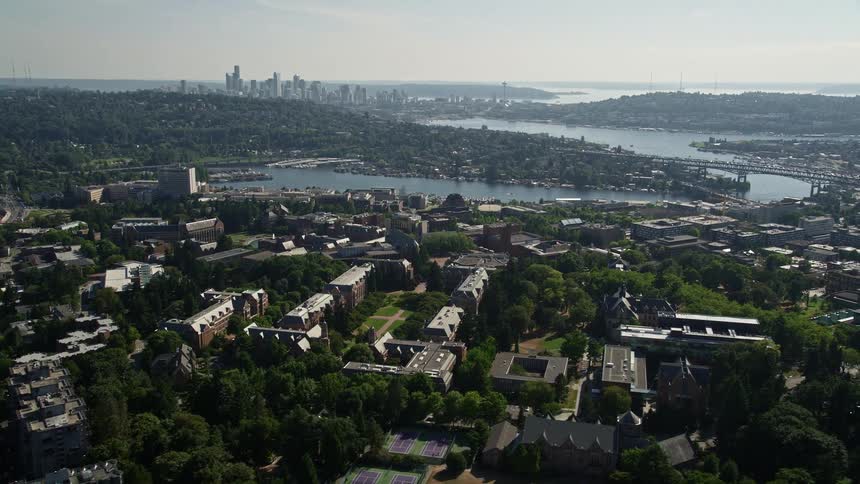 Aerial footage showcasing the University of Washington campus Portage Bay Lake Union and the downtown Seattle skyline on a sunny day in Washington State