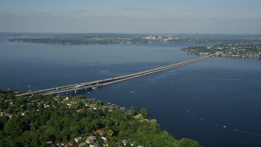 Aerial view of Lacey V Murrow Memorial Bridge spanning Lake Washington with boats sailing and neighborhoods along the coast in Seattle Washington