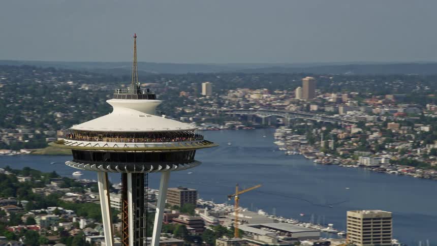 an aerial orbit around the iconic Space Needle showcasing the vibrant urban landscape of Downtown Seattle Washington on a sunny day