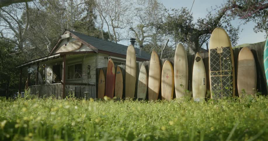 A lot of surf boards outdoors at a house