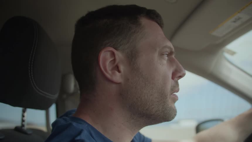 A man driving a car down a road