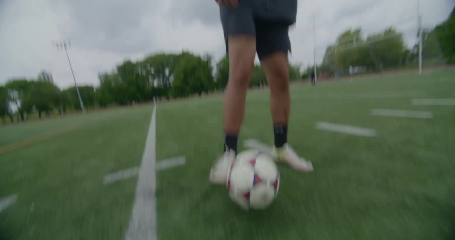 A man kicks a soccer ball around alone