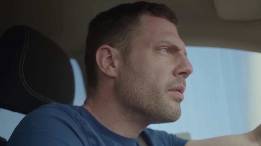 Man leans forward while driving car