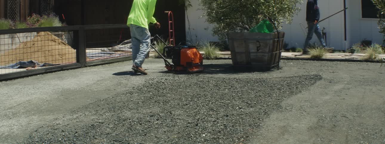 A man sands freshly poured concrete