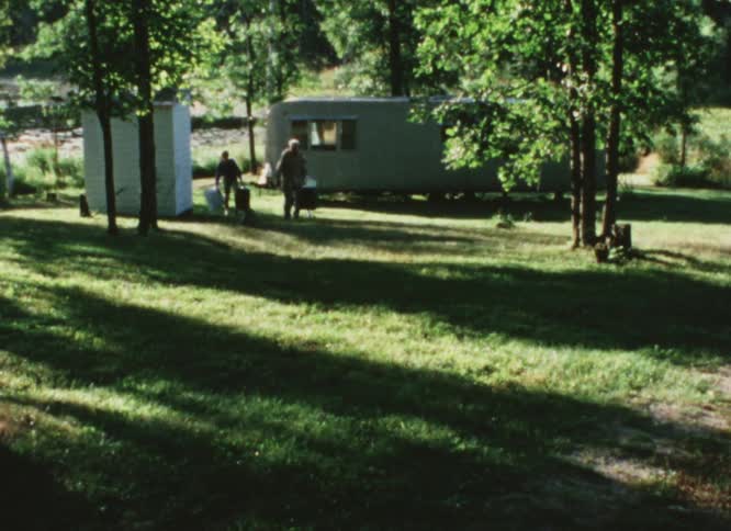Family on vacation leaves the trailer behind while carrying luggage caught on vintage film
