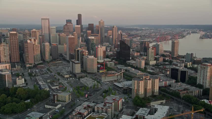  aerial footage of Downtown Seattle skyscrapers during sunset capturing the Central Waterfront piers and the iconic Seattle Great Wheel