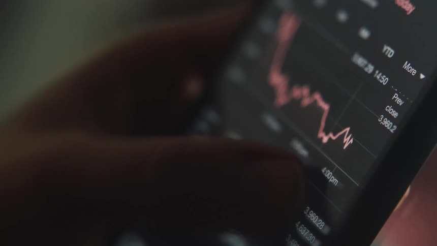 A person checks the stock market on their phone