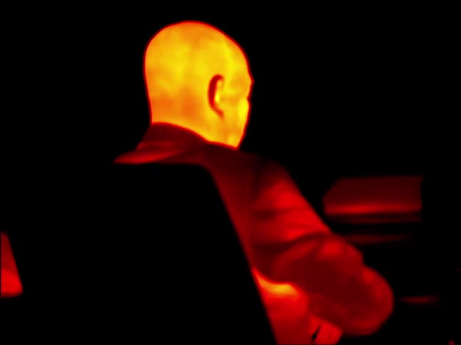 A heat map view of a man sitting on an office chair while someone talks to him