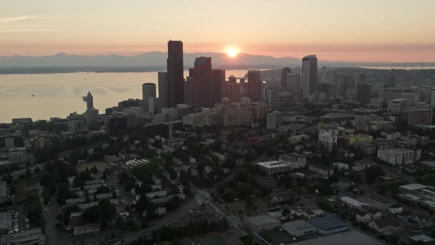 Aerial view of Downtown Seattle skyscrapers and high-rises with the setting sun in the background