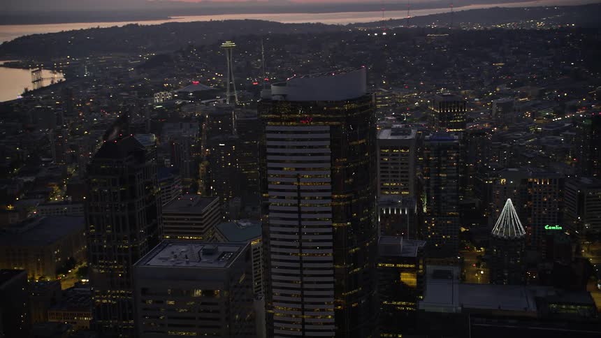 An aerial orbiting view of Two Union Square skyscraper at twilight in downtown Seattle Washington with clear skies and a stunning city skyline