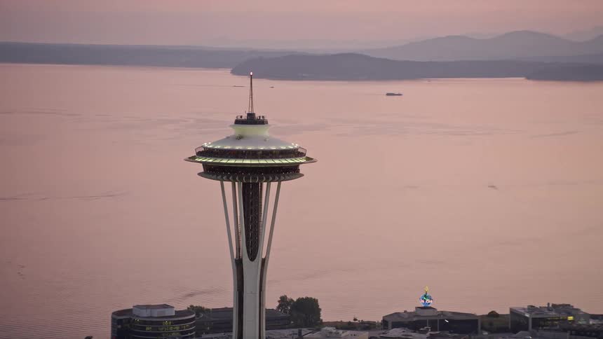 An aerial view of the iconic Seattle Space Needle in downtown Seattle Washington during sunset as it orbits the top providing an sightseeing experience