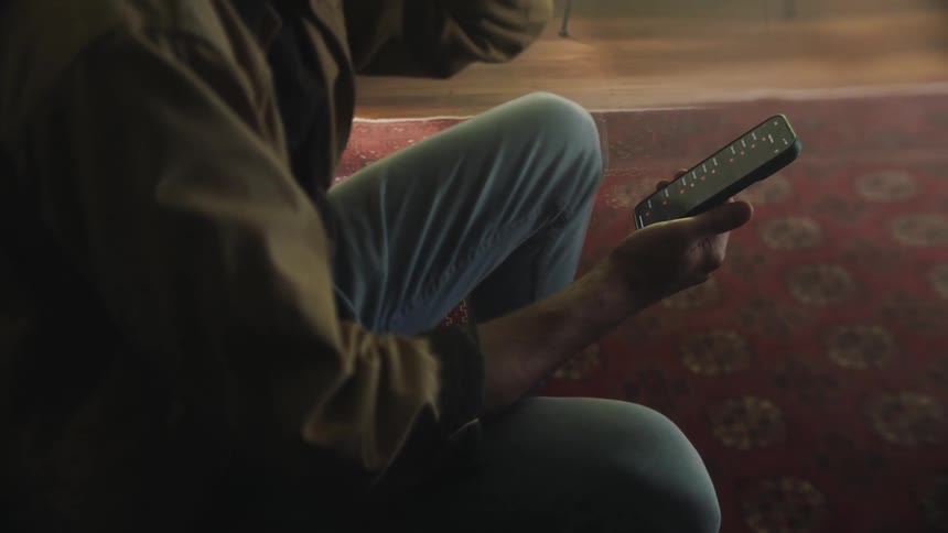 Man sits at home and scrolls smartphone screen
