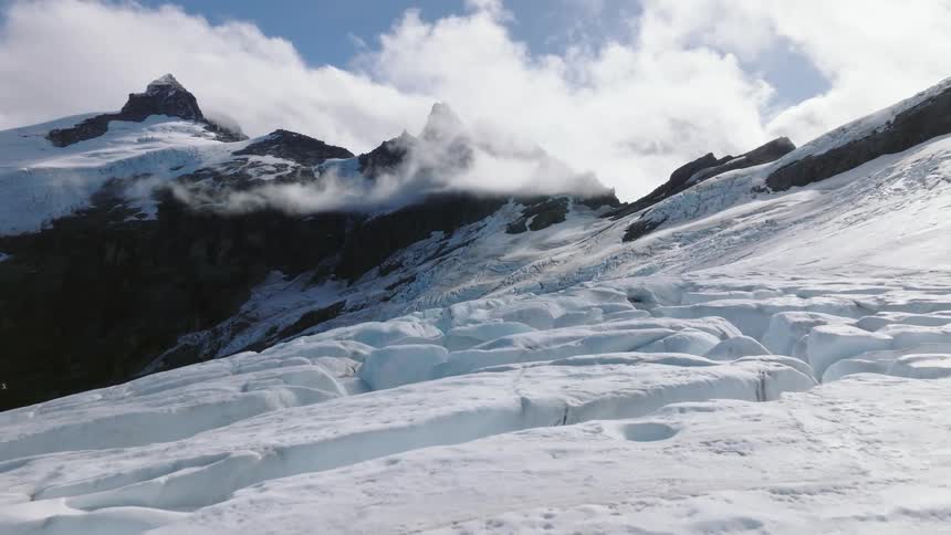 Aerial view of snowy mountain range glacier below