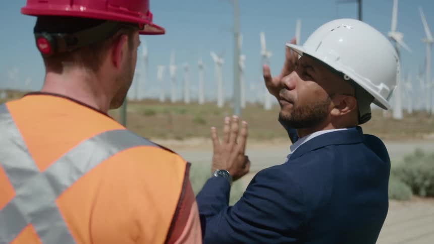 Engineers chat outside a wind farm