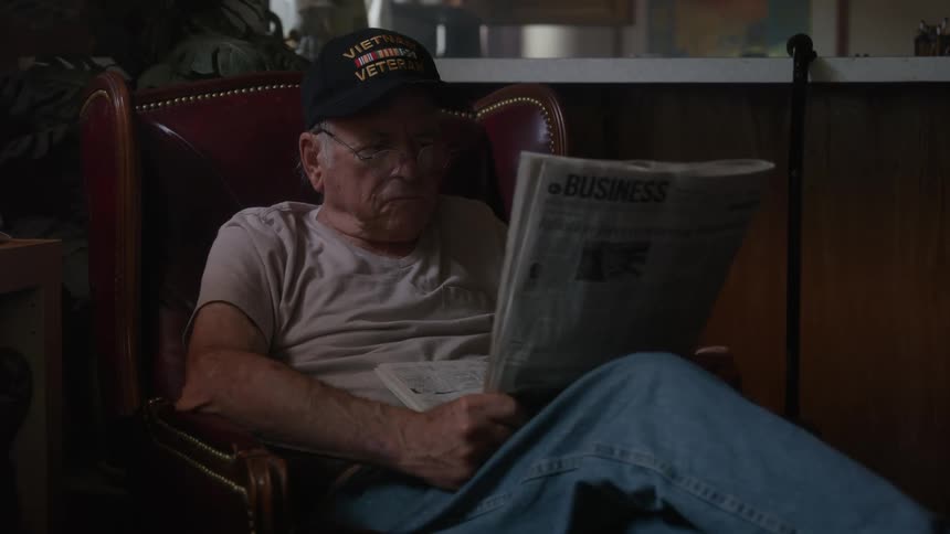 A man reads the newspaper at home