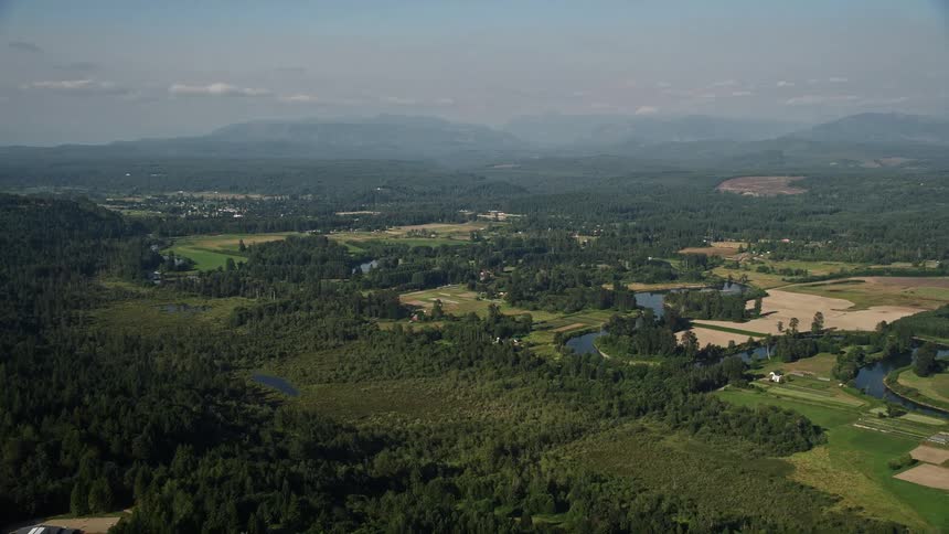 Approaching the Snoqualmie River this aerial footage captures the rustic farmland of Carnation Washington with the winding river snaking through the landscape
