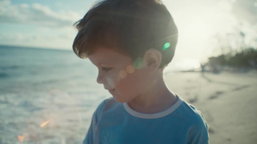 A child is smiling on the beach