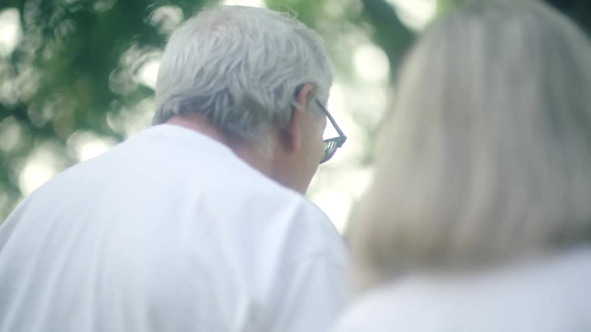Woman and man are sitting by each other outdoors