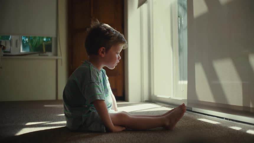 A child coughs while sitting inside