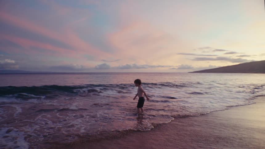 A child runs into the water