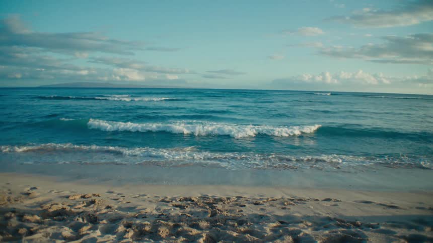 Tiny waves crash onto a beach
