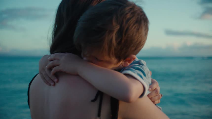 A mother is hugging her son