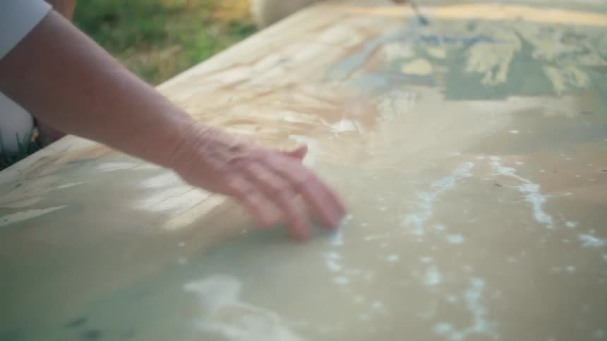 Two people are painting an object