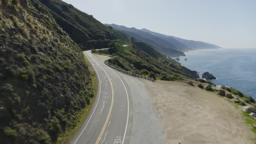 A highway runs along the side of a coastal mountain