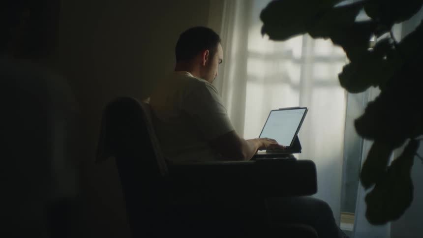 The view is of a portrait of a man that is on his laptop