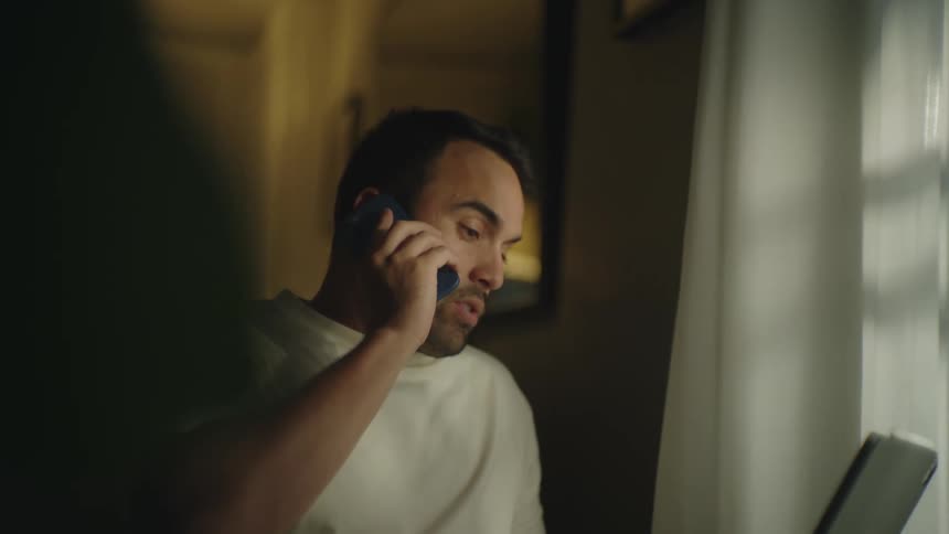 A man talking on a phone while sitting around