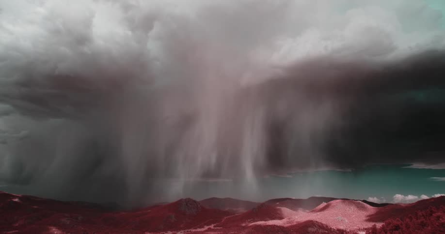 A landscape with red mountains full of clouds with a crystalline sea in the background