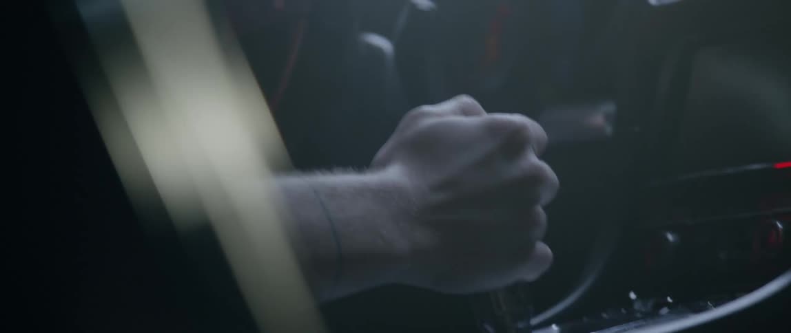 Man shifts gears in a speeding car