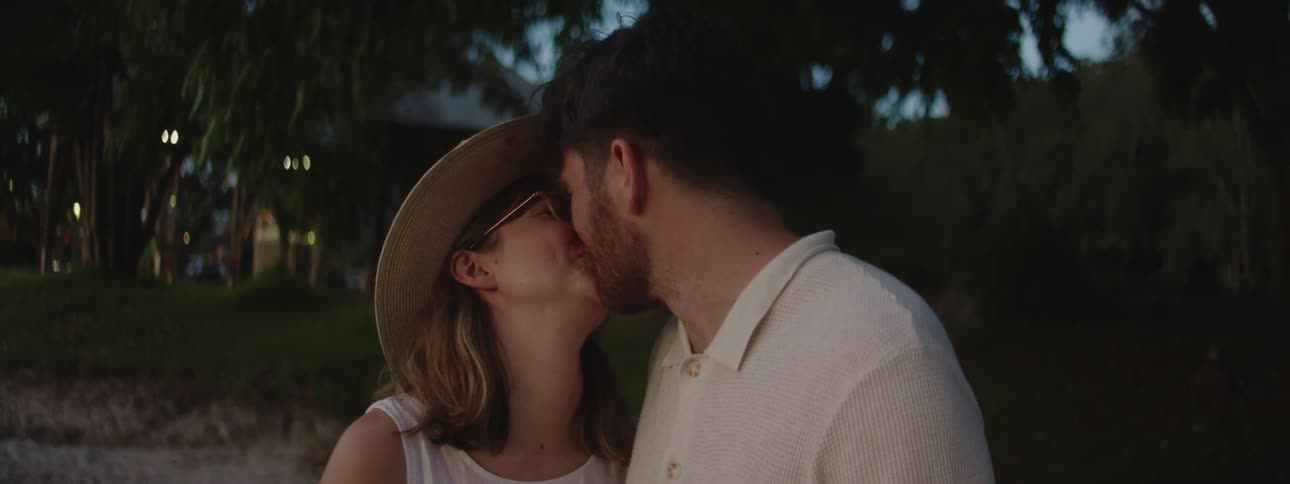 Mom and dad stealing a kiss at the summer lake house at nighttime