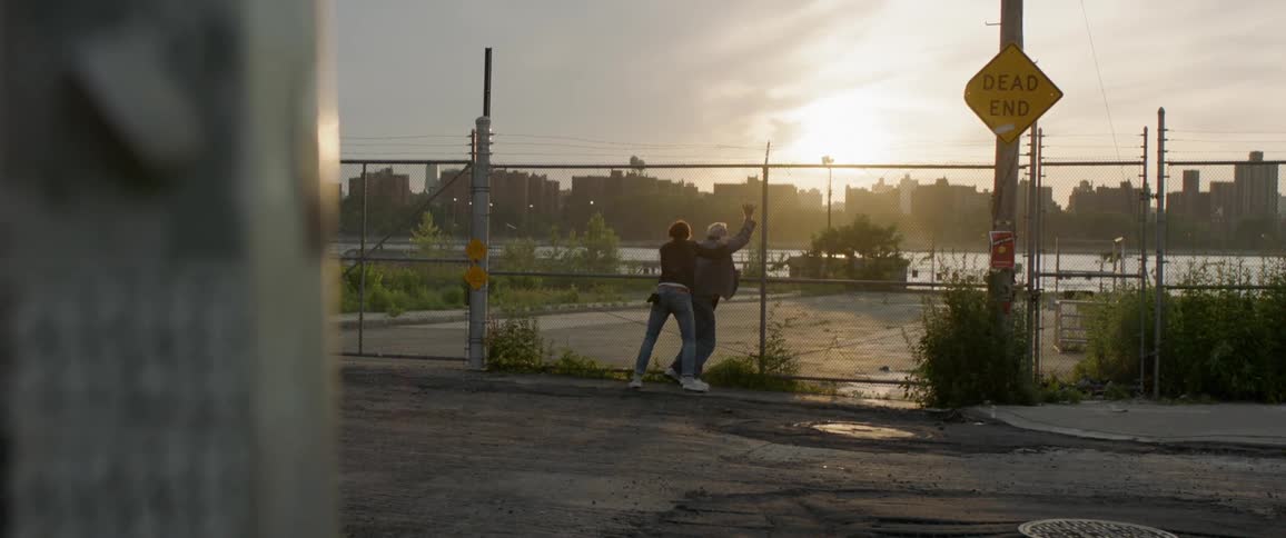 Two man fighting against a fence